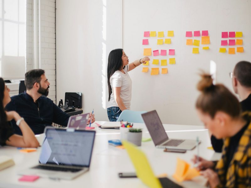 Team planning a project with sticky notes on a wall